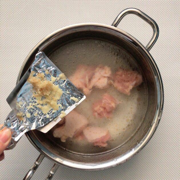 鶏肉とおろし生姜を鍋に入れている画像