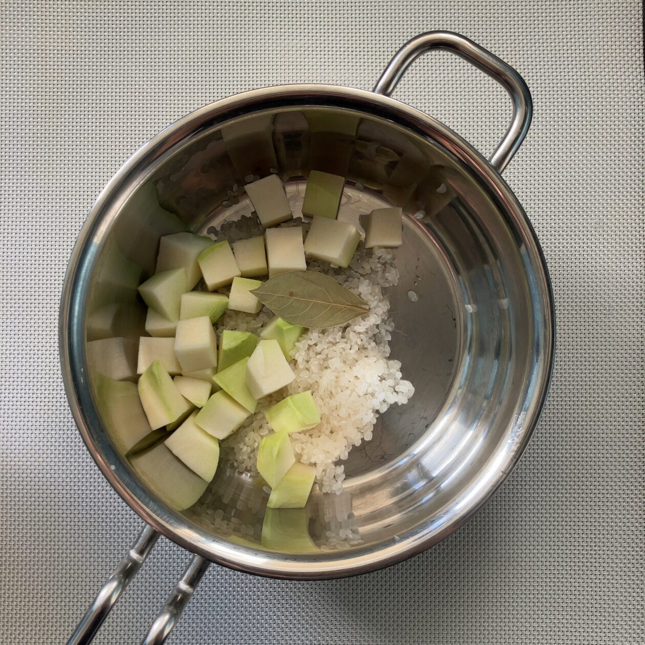 研いだ米、角切りにしたコールラビ、ローリエを鍋に入れた画像