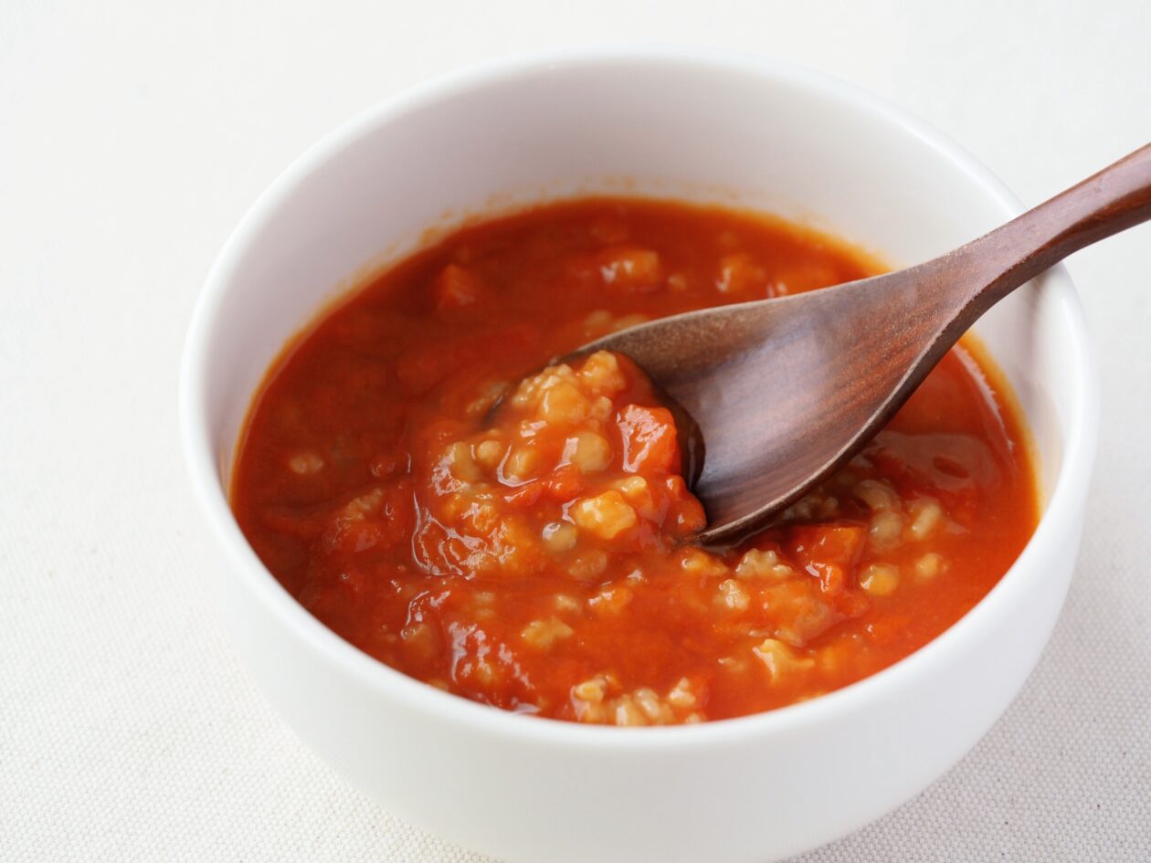 もち麦のポタージュ粥トマトスープ仕立てをすくっている画像