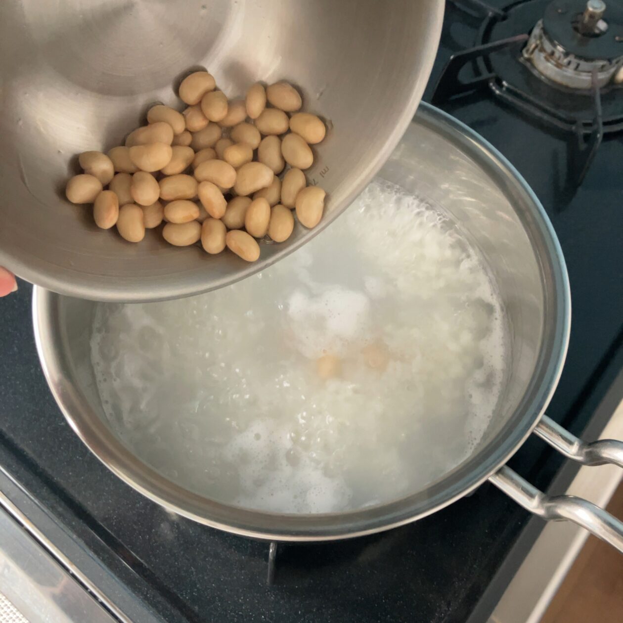 大豆の水煮を鍋に入れている写真
