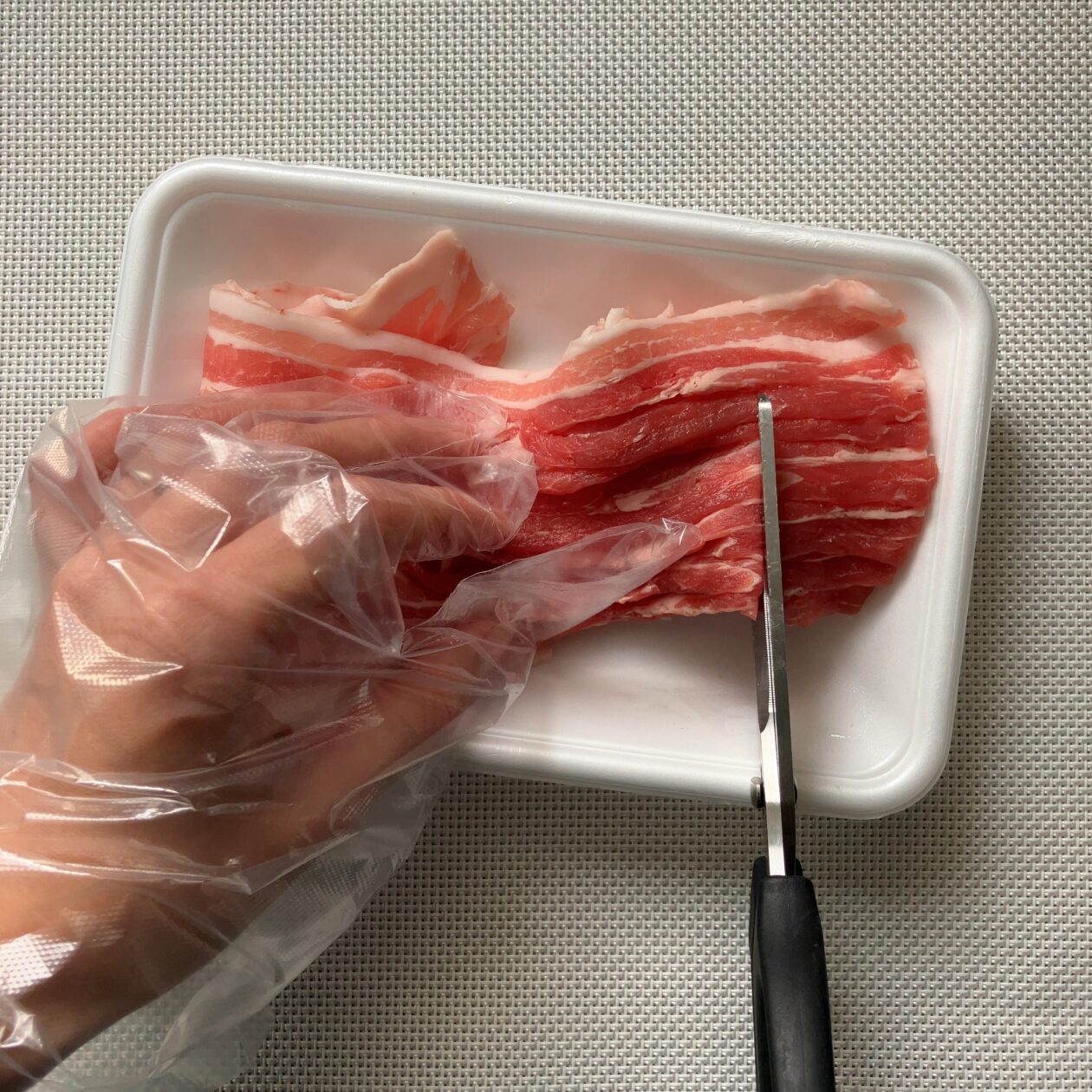 キッチンバサミで肉を切っている写真