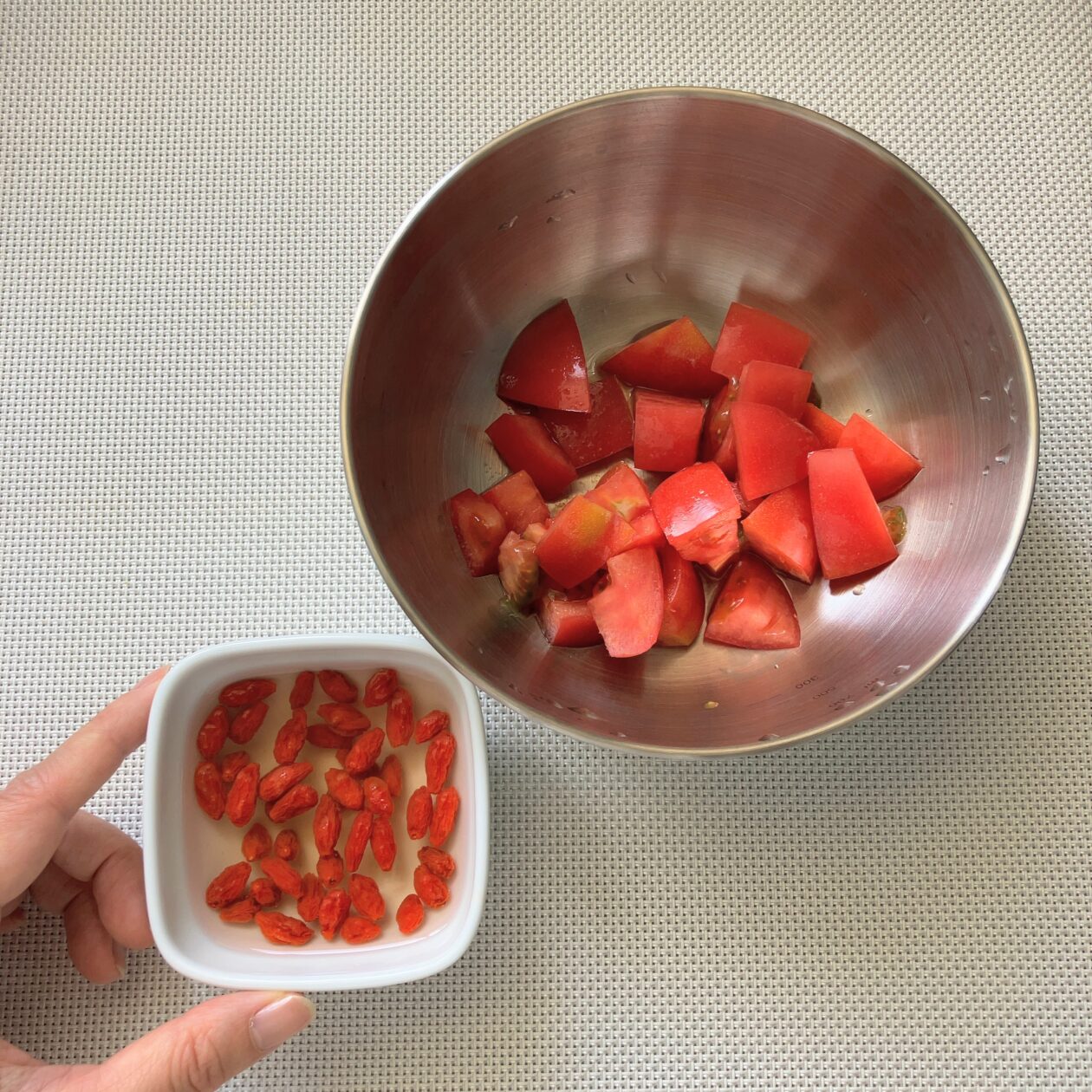 トマトを切って、クコの実を水に浸している写真