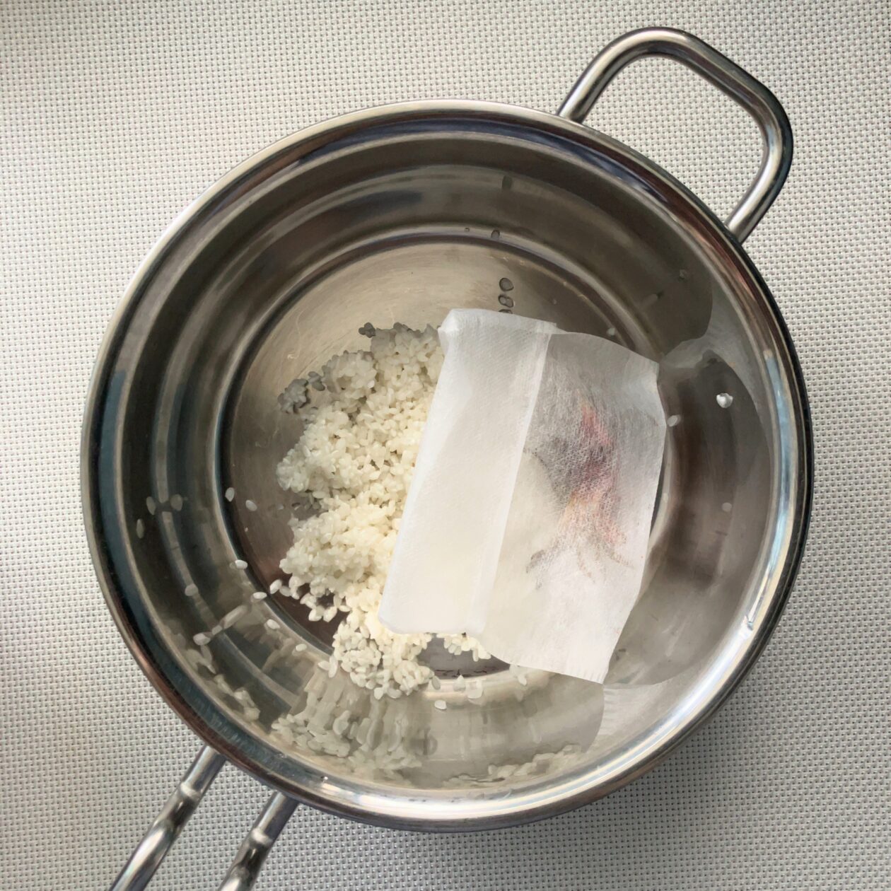 鍋に米とくちなしを入れた写真