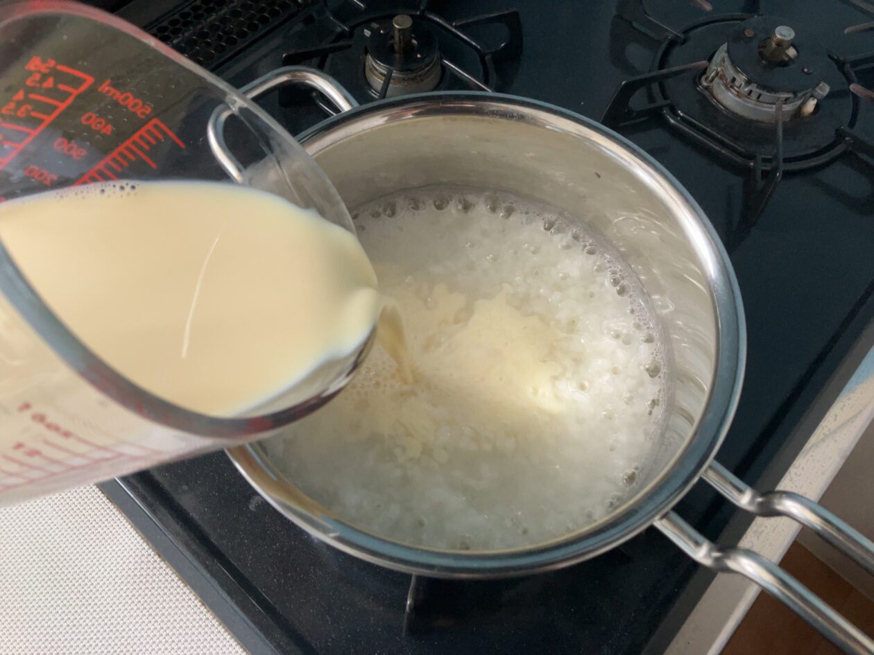 豆乳を鍋に入れている写真