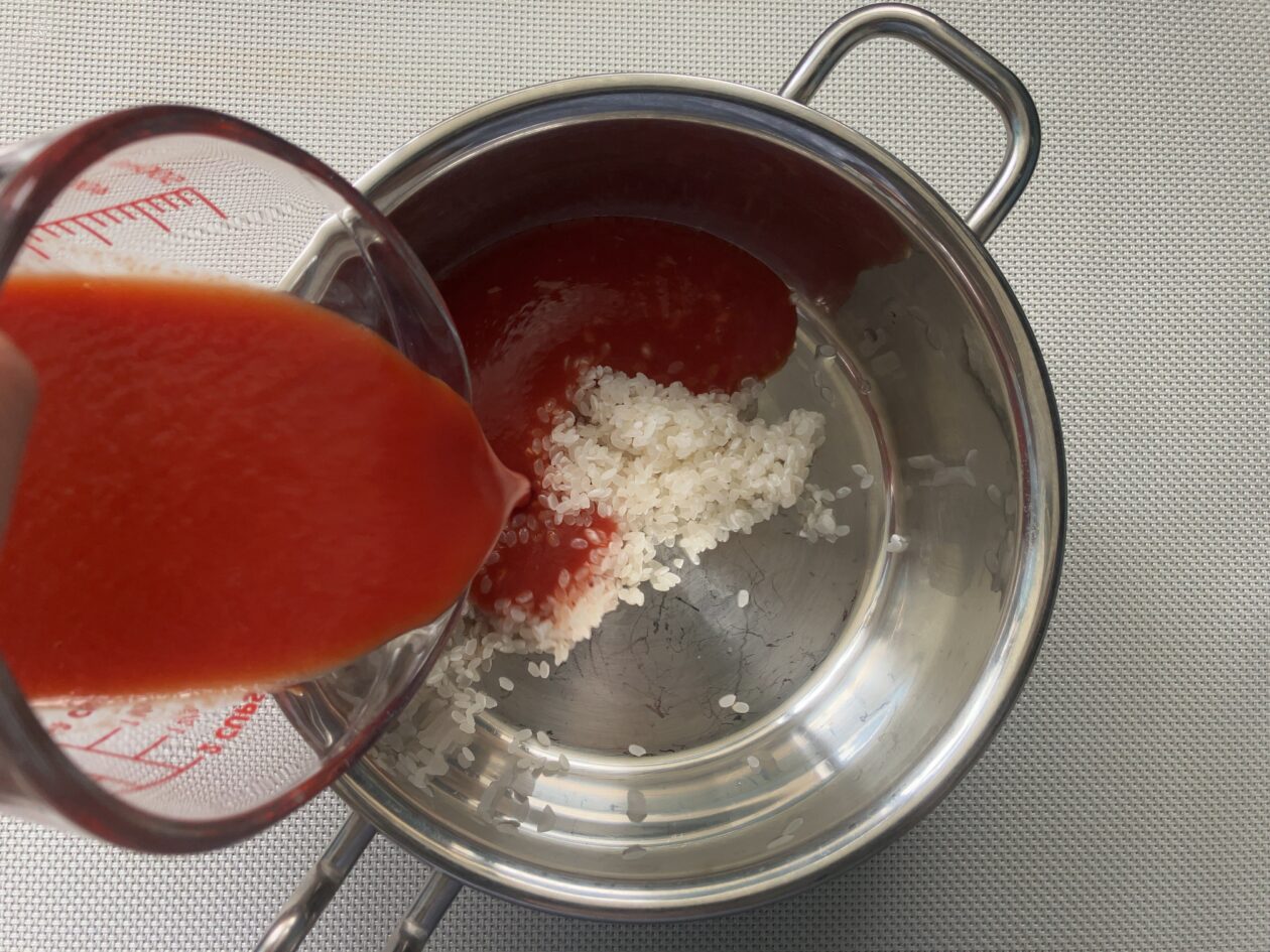 鍋にトマトジュースを入れる写真