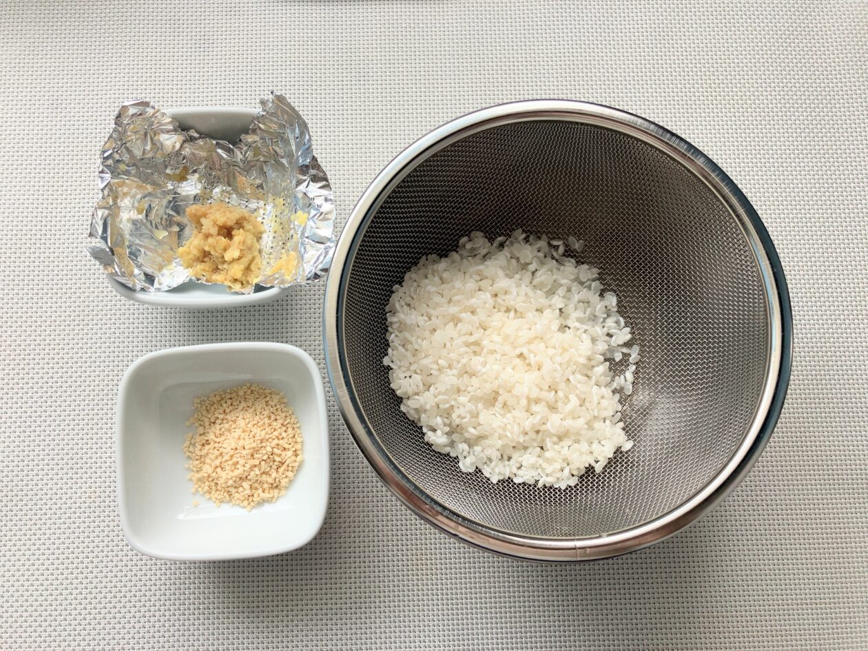 研いだ米、おろした生姜、小さじ2の顆粒だしの写真