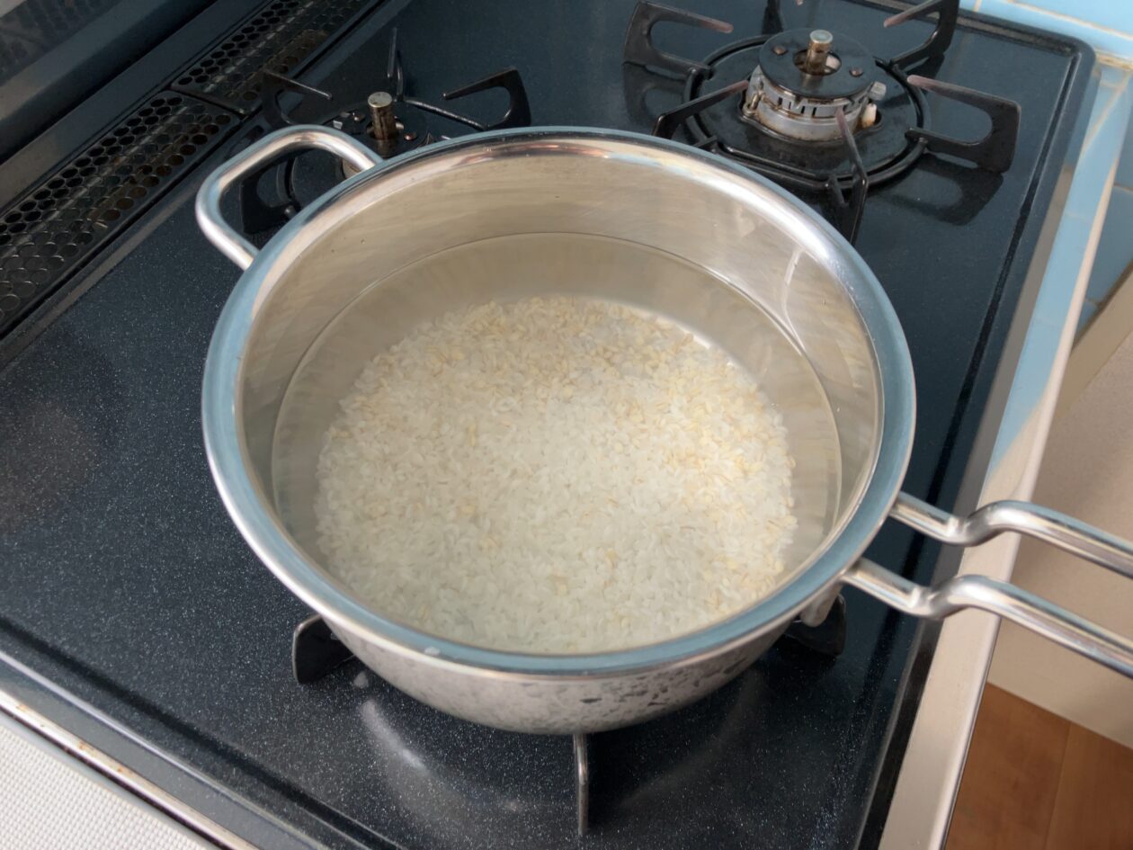 米ともち麦、水を入れた鍋を火にかけている写真