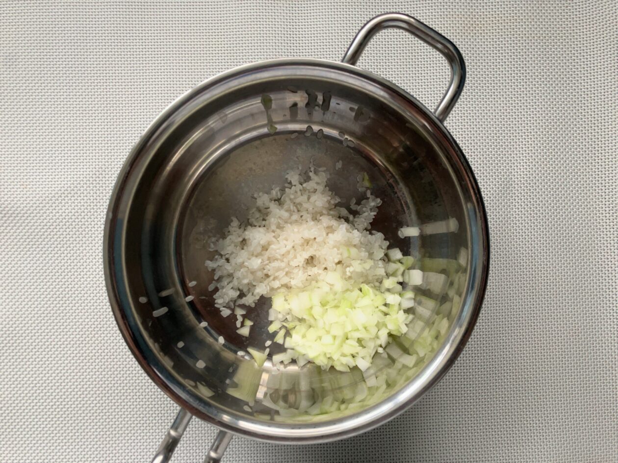 鍋に米と玉ねぎを入れた写真
