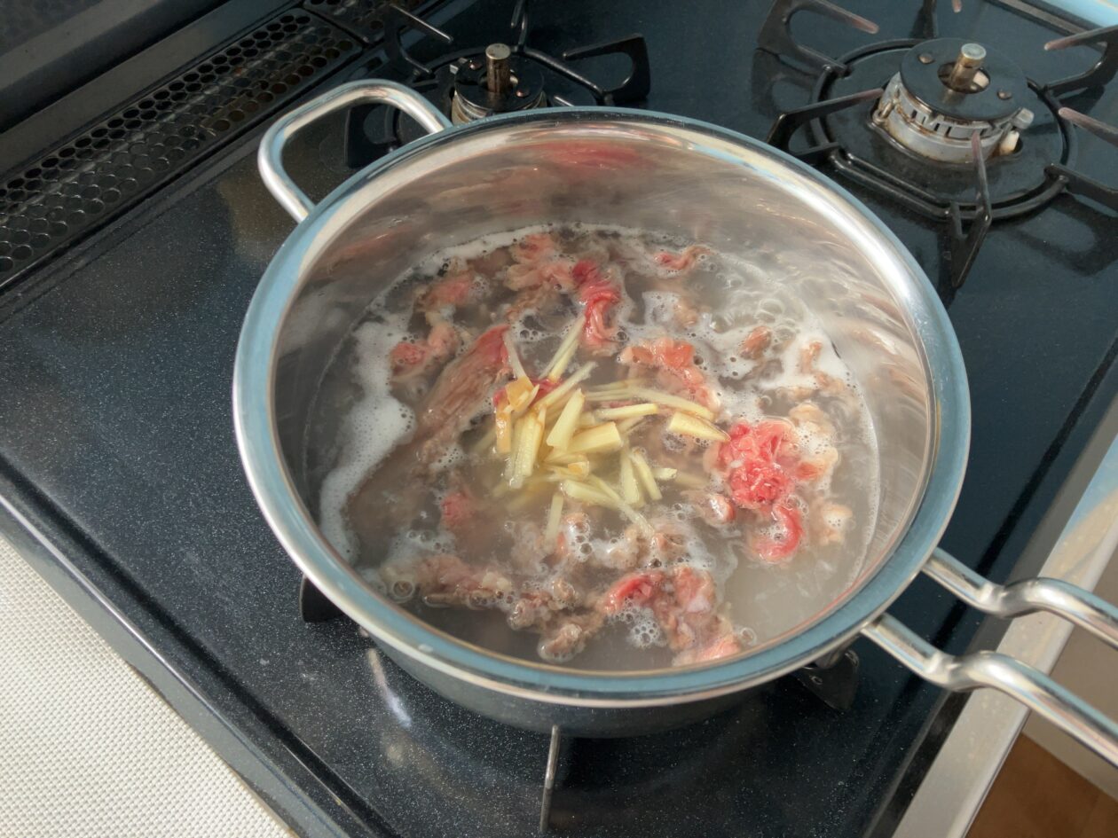 鍋に牛肉と生姜を入れた写真