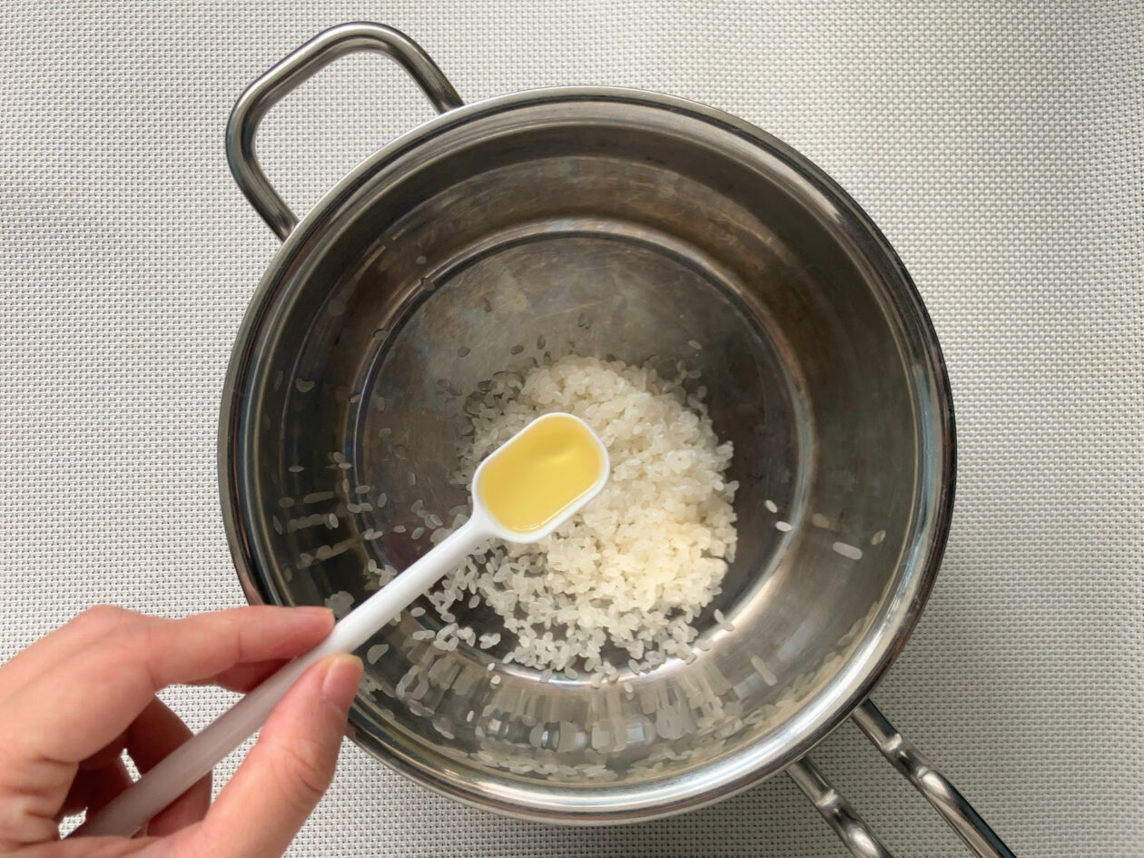 鍋に小さじ１杯の米油を入れている写真