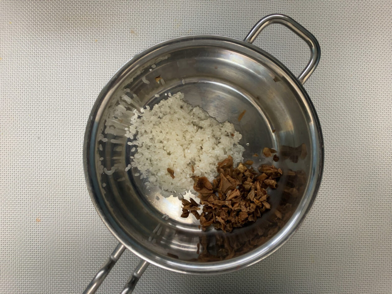 鍋に米とポルチーニを入れた写真